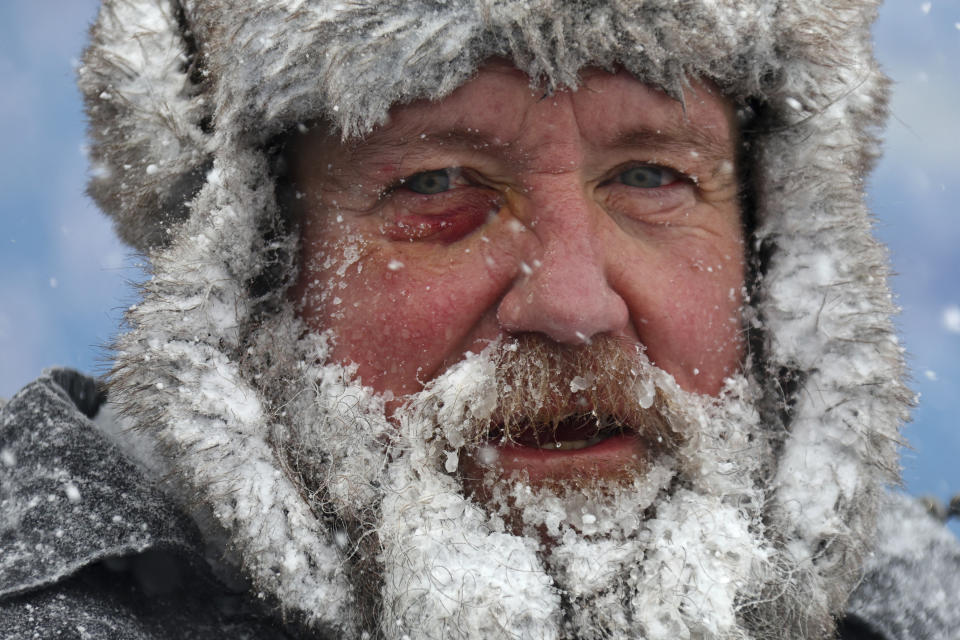 A stadium worker pauses while removing snow.