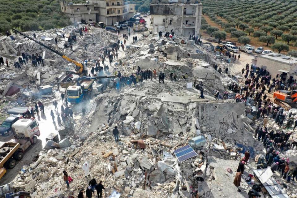 Residents, aided by heavy equipment, search for survivors amid the rubble of collapsed buildings in Syria’s rebel-held Idlib province on the border with Turkey.