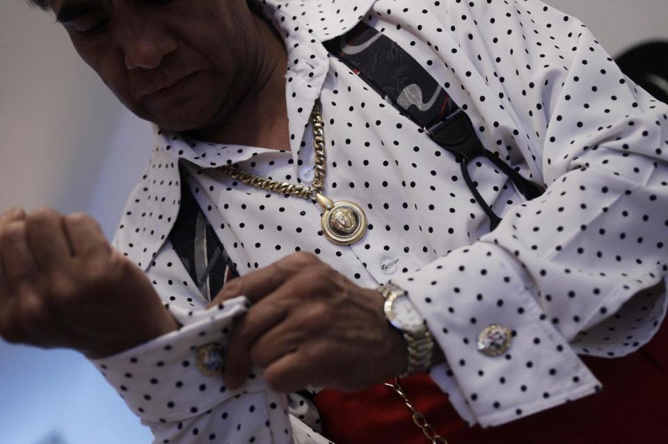 Jesus Gonzalez de la Rosa puts on cufflinks while dressing up as a "Pachuco" at his home in Mexico City