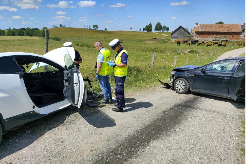 Police officers are investigating the site of a crash between the white Toyota of eight-time world rally champion Sebastien Ogier and co-driver Vincent Landais, left, and a local resident's Ford, right, that collided head-on on a local road near the village of Wlosty, near Goldap in northeastern Poland, Tuesday, June 25, 2024, while the Ogier and Landais were on a reconnaissance run ahead of this week's Rally Poland. Ogier and the Ford's driver were airlifted to hospital while Landais and the Ford's female passenger were taken by ambulances. (Police Office in Goldap via AP Photo)