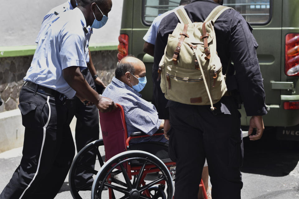 Antigua and Barbuda businessman Mehul Choksi is taken in a wheelchair to the magistrate's court by police in Roseau, Dominica, Friday, June 4, 2021. Choksi is wanted in his native India on a string of charges that include corruption, money laundering and criminal conspiracy. The fugitive was arrested May 24 on the neighboring island of Dominica accused of illegal entry. (AP Photo/Clyde Jno Baptiste)