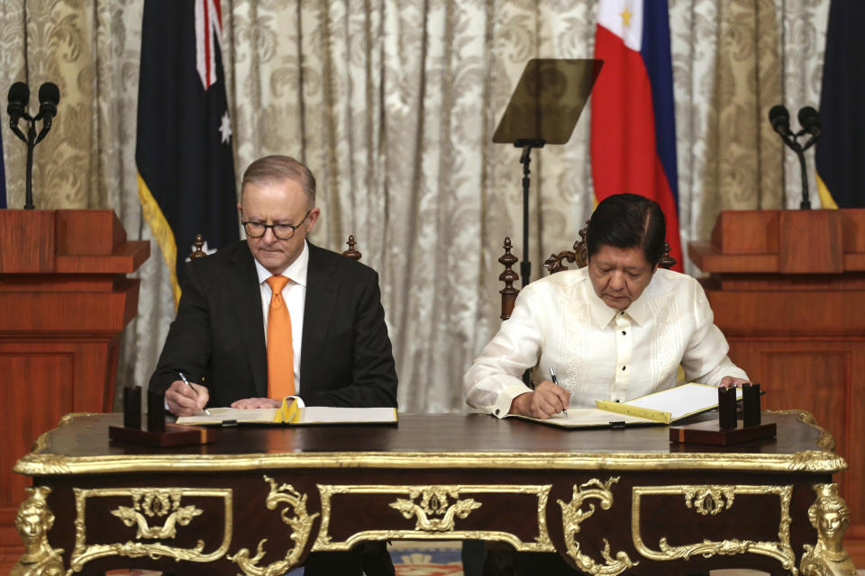 Australia's Prime Minister Anthony Albanese, left, and Philippine President Ferdinand Marcos Jr., right, sign the Memorandum of Understanding during his visit at the Malacanang palace in Manila Friday, Sept. 8, 2023. (Earvin Perias/Pool Photo via AP)