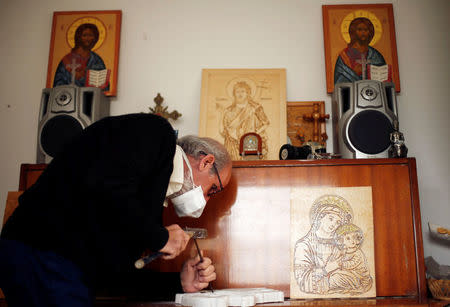 Christian artist and sculptor Naser Jeldha crafts a sculpture in his studio in Gaza City December 4, 2016. REUTERS/Suhaib Salem