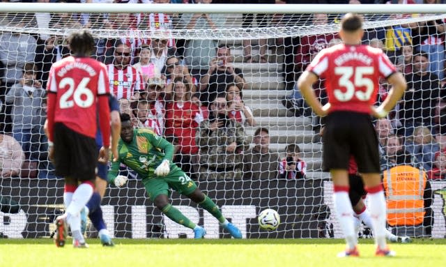 Andre Onana dives to his right to save Cameron Archer's penalty