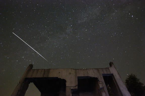 Stars and meteor streaks are seen behind a destroyed house, near Tuzla, Bosnia on Aug. 12, 2015.