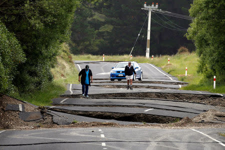 Local residents Chris and Viv Young look at damage caused by an earthquake along State Highway One near the town of Ward, south of Blenheim on New Zealand's South Island, November 14, 2016. REUTERS/Anthony Phelps