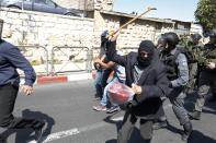 An undercover Israeli policeman, dressed as an old man (C) holds up his walking stick as a Palestinian is arrested (rear) during clashes following Friday prayers near Damascus Gate in Jerusalem's Old City September 27, 2013. An Israeli police spokesman said on Friday that 10 Palestinians were detained on suspicion of throwing stones at policemen who were deployed in the Old City and in nearby Palestinian neighborhoods of Jerusalem, amid recent tensions over Israel's admittance of Jewish visitors to a holy site in the Old City, which houses the al-Asqa mosque, and which Jews revere as the vestige of their ancient temples. Also on Friday, Israeli police only permitted Palestinian males over the age of 50 to enter al-Aqsa mosque. (REUTERS/Baz Ratner)