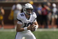 Connecticut quarterback Cale Millen rolls out against Michigan in the first half of an NCAA college football game in Ann Arbor, Mich., Saturday, Sept. 17, 2022. (AP Photo/Paul Sancya)