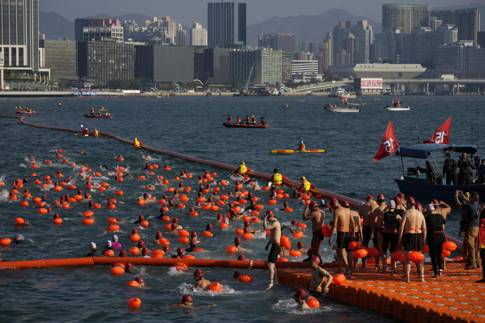 Competitors swim during a harbor race at the Victoria Harbor in Hong Kong, Sunday, Dec. 12, 2021. Hundreds of people took part in traditional swim across iconic Victoria Harbor after two years of suspension. (AP Photo/Kin Cheung)