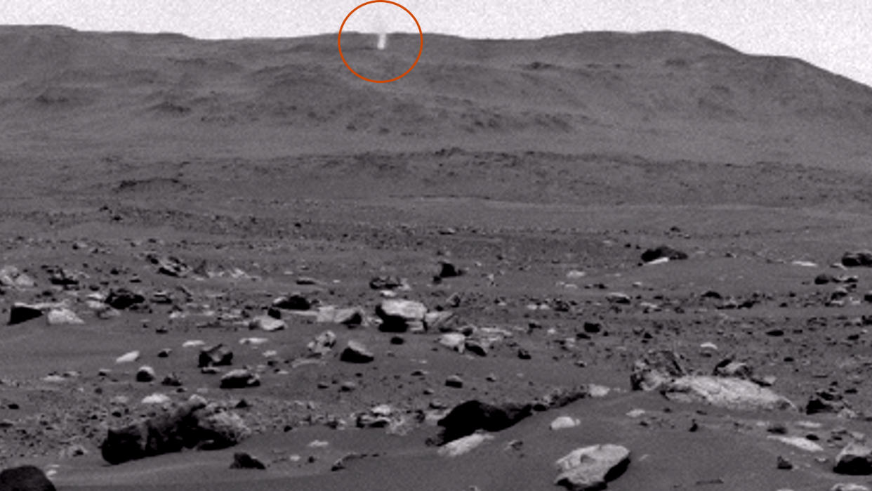  A black and white image of the surface of Mars with a small twister on the horizon (circled). 