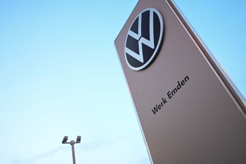 The Volkswagen logo stands in front of the entrance to the Emden plant. Lars Penning/dpa