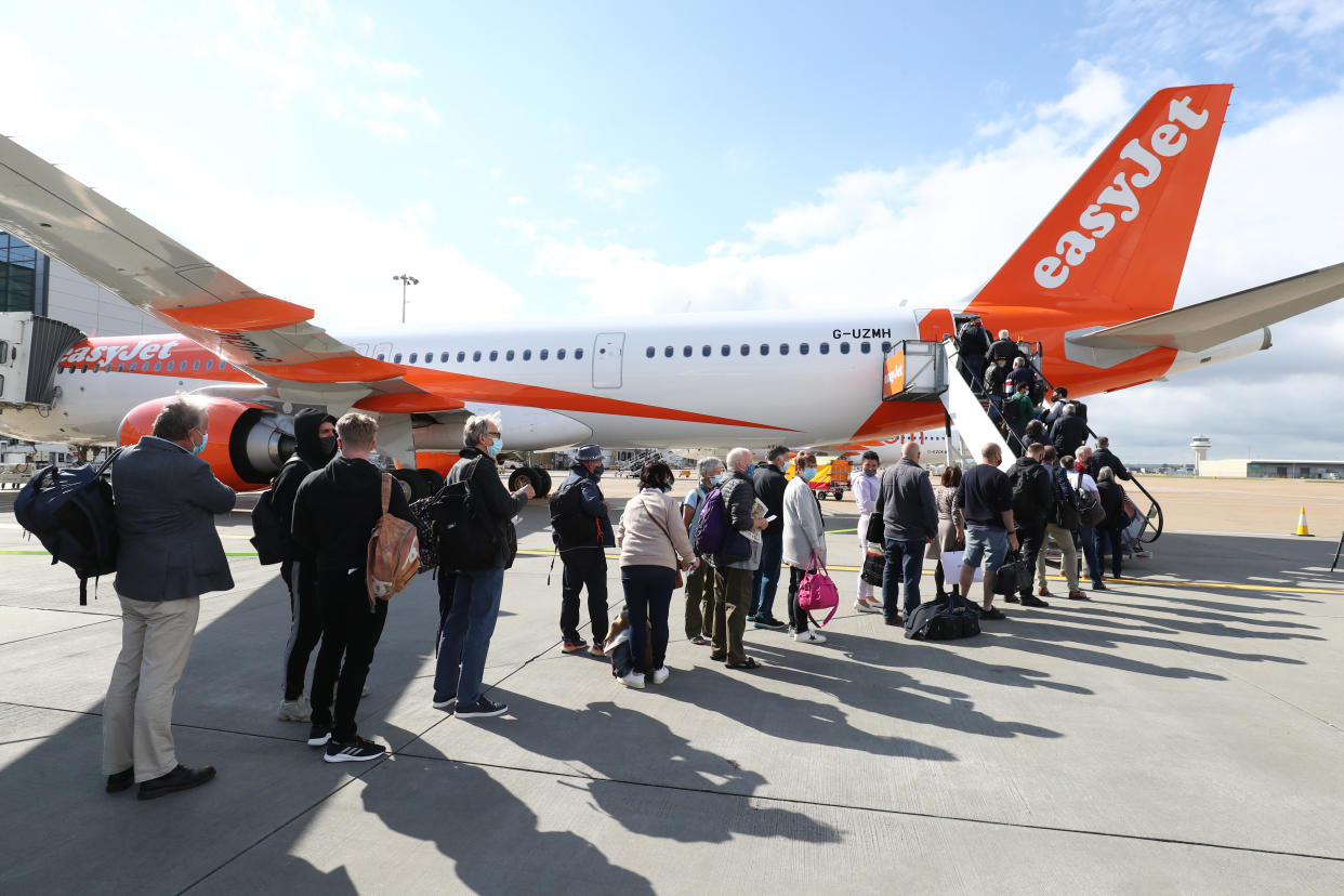 File photo dated 17/05/21 of passengers prepare to board an easyJet flight to Faro, Portugal, at Gatwick Airport in West Sussex, as the airline hopes to be back to carrying nearly as many customers at the end of this financial year as it did before the pandemic.