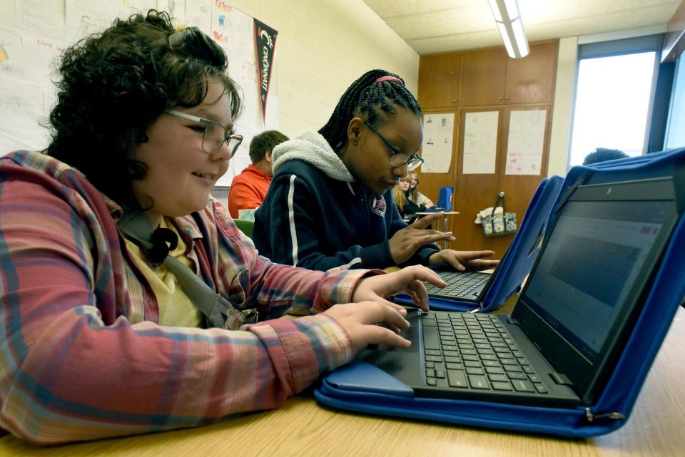 Wagar Middle School eighth grader Elly Wickenheiser, 13, of Carleton, works on her American Revolution assignment in Social Studies alongside classmate Kathleen Calloway.