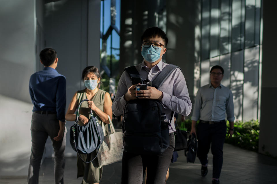 SINGAPORE - 2020/02/17: Office workers wearing protective face masks after working hours following the corona virus threat. Singapore declared the COVID-19 outbreak as Code Orange on February 7, 2020. (Photo by Maverick Asio/SOPA Images/LightRocket via Getty Images)