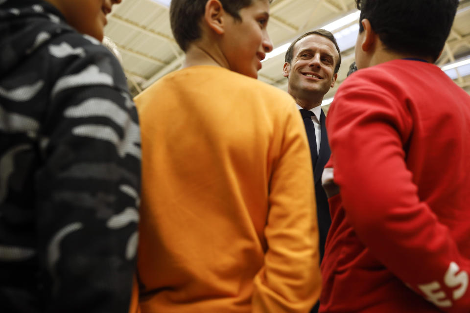 French President Emmanuel Macron, talks with youths during his visit in Mulhouse, eastern France, Tuesday, Feb. 18, 2020. Macron said Tuesday he was determined to fight against "Islamist separatism" but also "discrimination ». (AP Photo/Jean-Francois Badias, Pool)