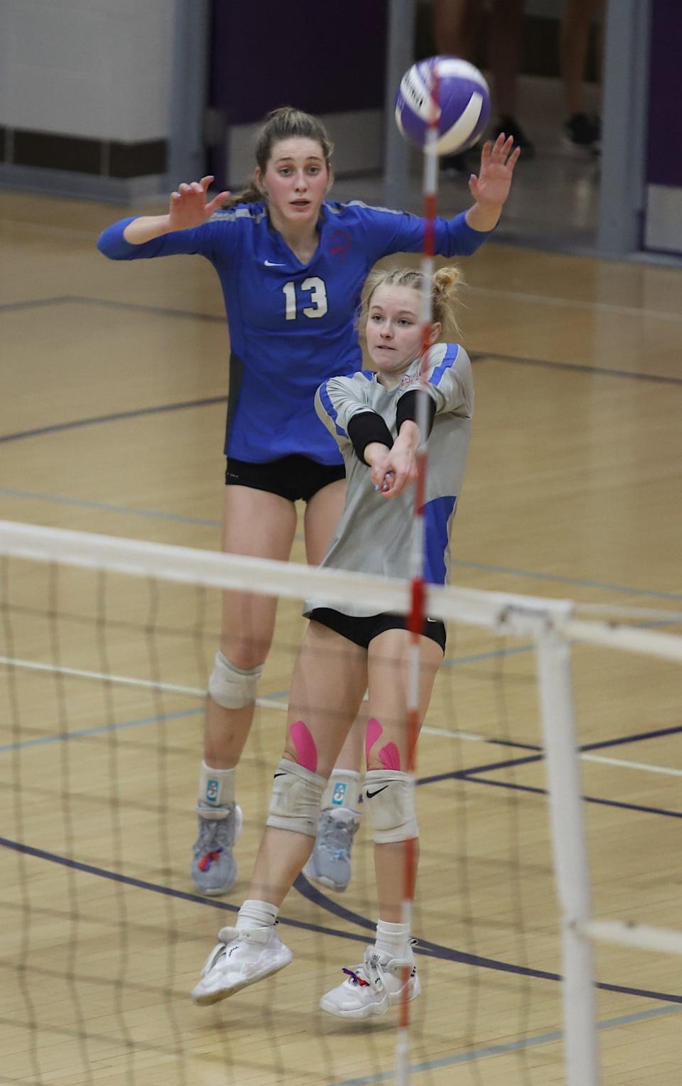 Holy Trinity’s Teagan Snaadt (1) bumps the ball as Mary Kate Bendlage (13) avoids contact against Notre Dame in a Class 1A regional final Wednesday in Burlington. Holy Trinity won the match, 3-1.