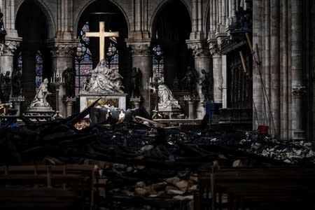 A picture shows rubbles and the cross at the altar, inside the the Notre-Dame Cathedral after it sustained major fire damage from the previous month, during the visit of Canadian Prime Minister in Notre-Dame Cathedral in Paris