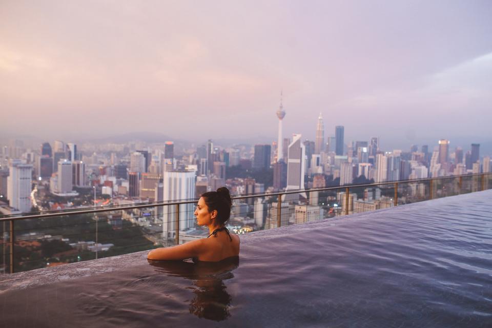 A woman in a pool swimming on top of a building in Kuala Lumpur, Malaysia.