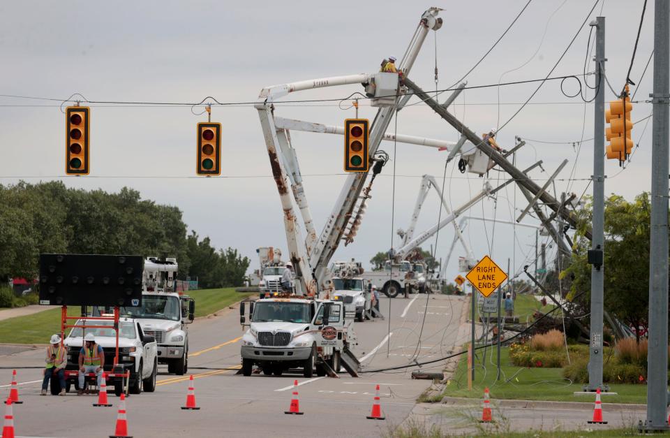 Repair crews work on power lines after several poles snapped and homes and businesses in the area lost power after a big thunderstorm and winds came through Commerce Township between 14 and 15 Mile Roads in the early morning hours of Thursday, Aug. 24, 2023.