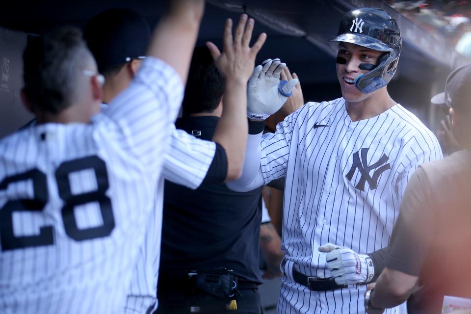 New York Yankees designated hitter Aaron Judge (99) celebrates in the dugout with teammates after hitting a two-run home run against the Kansas City Royals.