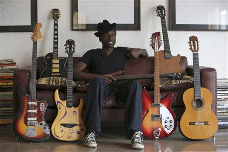 Nigerian musician Keziah Jones sits on a sofa between guitars during an interview with Reuters at his home in Lagos February 25, 2014. REUTERS/Akintunde Akinleye