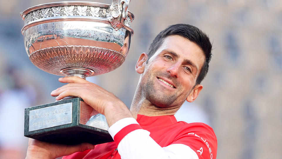 Seen here, 2021 champion Novak Djokovic poses with the French Open trophy he won at Roland Garros.