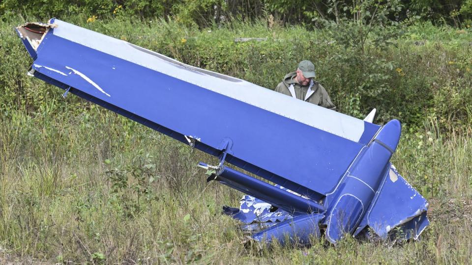 A Russian serviceman inspects a part of a crashed private jet near the village of Kuzhenkino, Tver region, Russia, Thursday, Aug. 24, 2023. (AP)