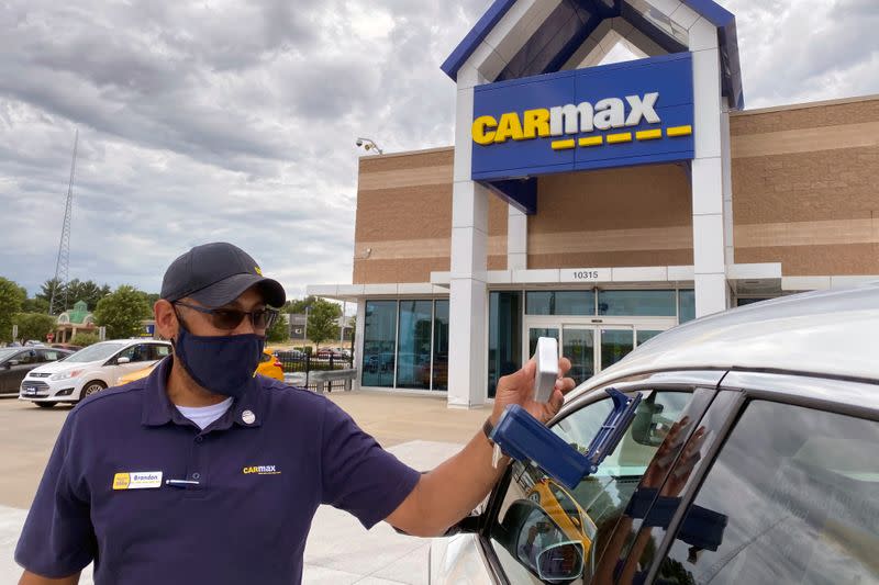 Brandon Parrum, general manager of CarMax's Des Moines store, shows off his vehicle