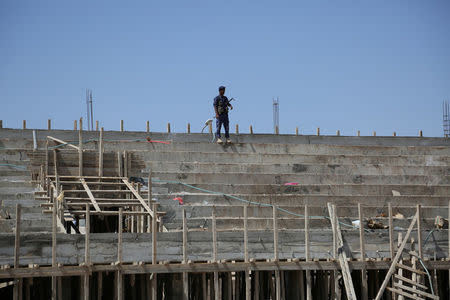 A pro-government police trooper stands at the site of an under-construction stadium in the northern city of Marib, Yemen November 4, 2017. REUTERS/Ali Owidha