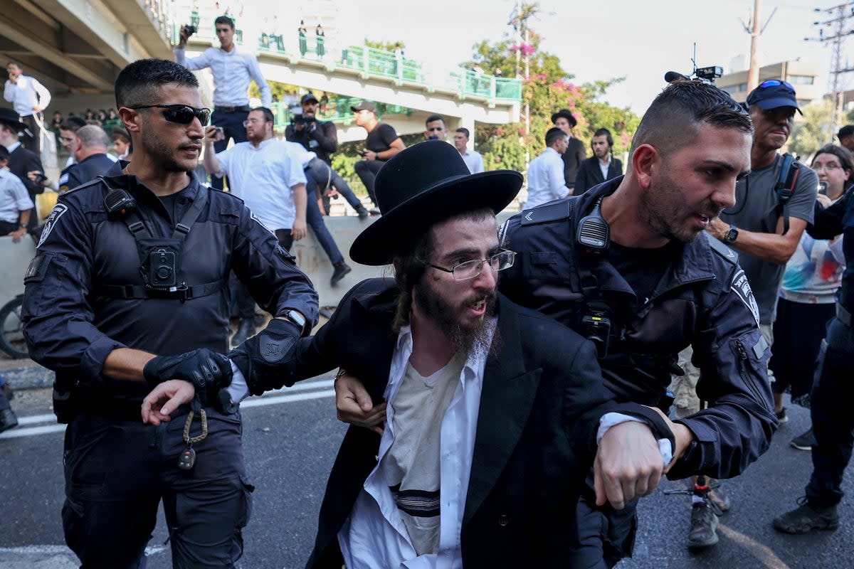 Police detain an ultra-Orthodox Jewish man during a protest against a ruling by a top Israeli court that they must be drafted into military service, in the Israeli city of Bnei Brak (Jack Guez / AFP via Getty Images)