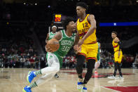 Boston Celtics guard Marcus Smart (36) drives past Atlanta Hawks forward De'Andre Hunter (12) during the first half of an NBA basketball game Friday, Jan. 28, 2022, in Atlanta. (AP Photo/Hakim Wright Sr.)