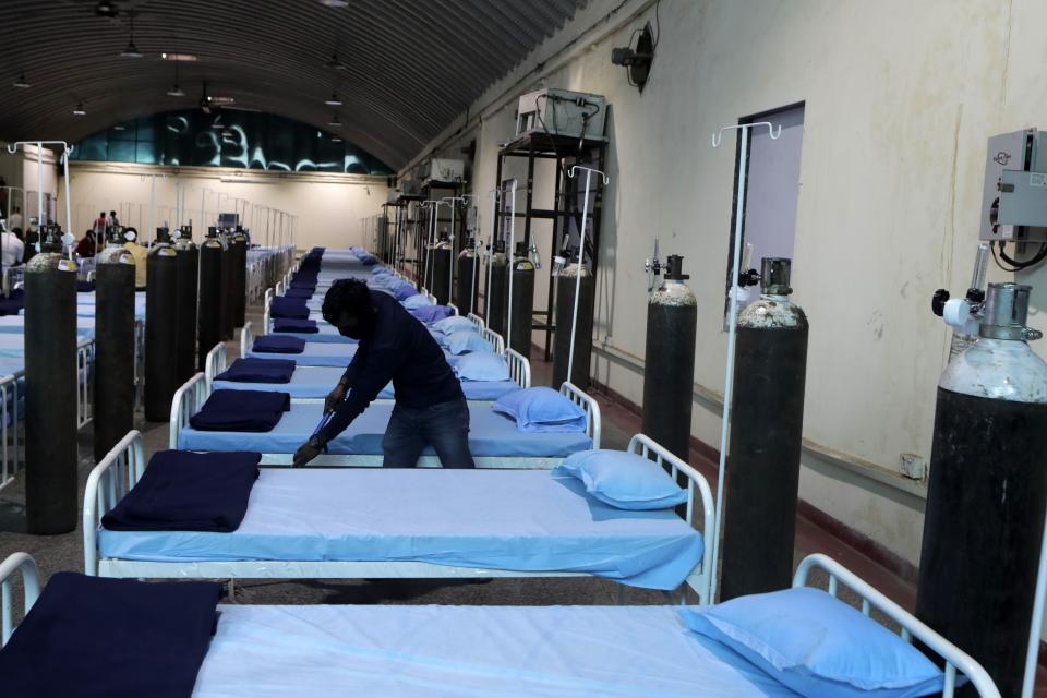 A worker cleans a newly set up C0VID- 19 hospital at Science Center in Mumbai, India, Tuesday April 13, 2021. India has been overwhelmed by hundreds of thousands of new coronavirus cases daily, bringing pain, fear and agony to many lives as lockdowns have been placed in Delhi and other cities around the country. (AP Photo/Rajanish Kakade)