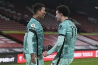 Liverpool's Roberto Firmino, left, celebrates scoring his side's second goal with Liverpool's Curtis Jones, right, who scored his side's first goal during the English Premier League soccer match between Sheffield United and Liverpool at Bramall Lane stadium in Sheffield, England, Sunday, Feb. 28, 2021. (Lee Smith, Pool via AP)