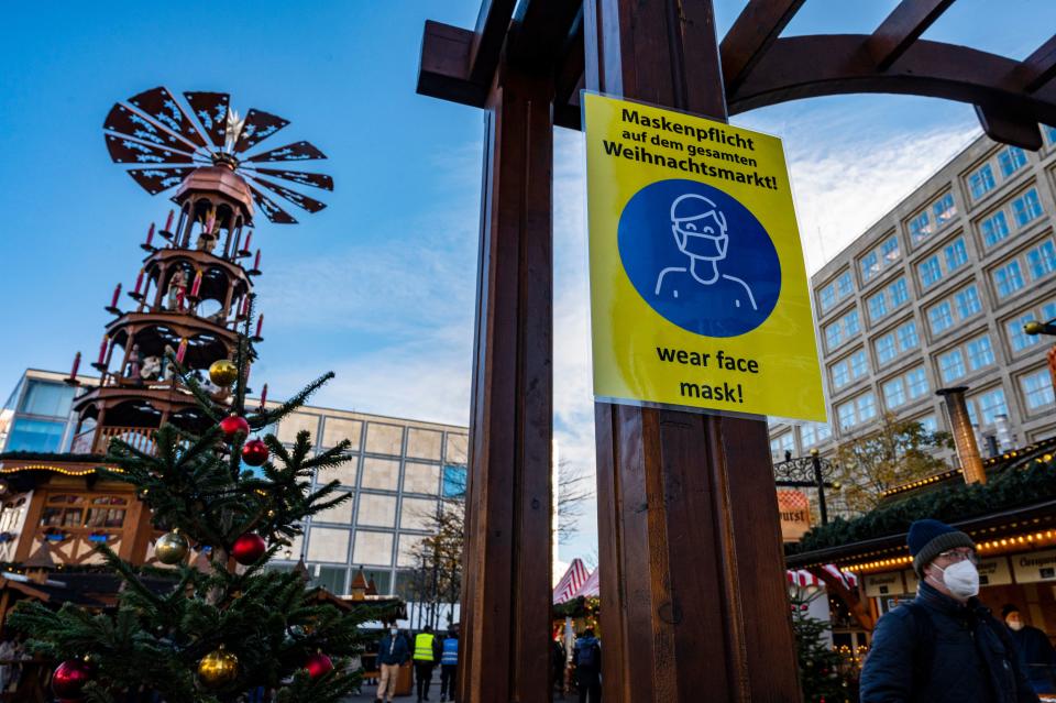 A sign requesting visitors to wear protective face masks is seen outside a Christmas market at Alexanderplatz in Berlin on November 22, 2021. - Some of the German federal states on November 19, 2021 cancelled all their Christmas markets and unveiled drastic curbs on public life as the country scrambles to contain soaring coronavirus infections. (Photo by John MACDOUGALL / AFP) (Photo by JOHN MACDOUGALL/AFP via Getty Images)