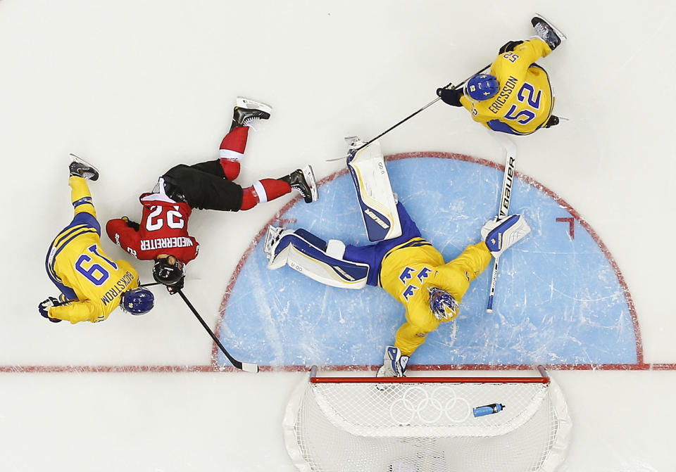Sweden goaltender Henrik Lundqvist blocks a shot on goal by Switzerland in the first period of a men's ice hockey game at the 2014 Winter Olympics, Friday, Feb. 14, 2014, in Sochi, Russia. (AP Photo/Julio Cortez )