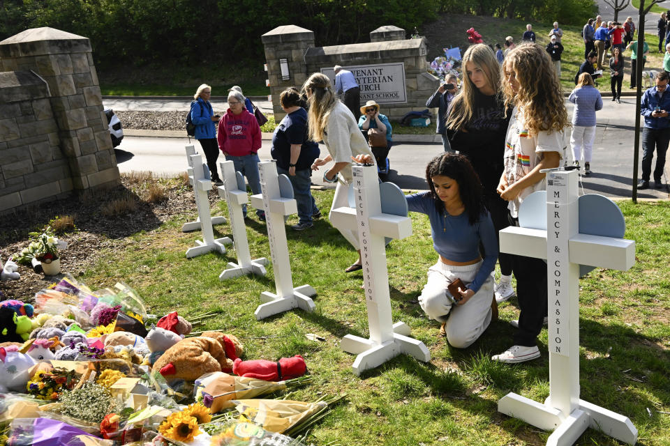 Three girls pay respects at a growing memorial for the victims of Monday' school shooting , Tuesday, March 28, 2023, at an entry to Covenant School in Nashville. (AP Photo/John Amis)