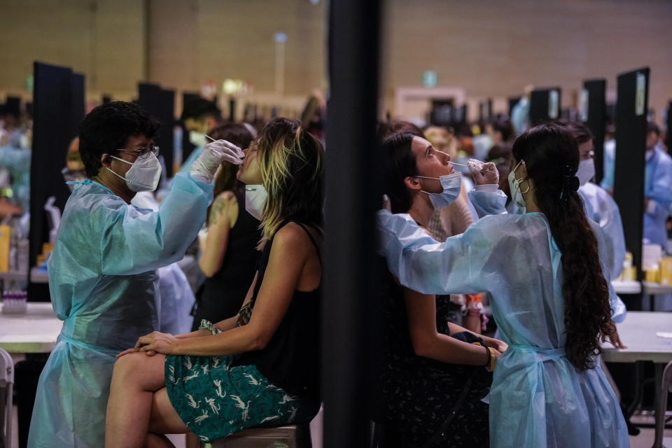 Health workers take swab samples collection for a COVID-19 antigen test ahead of the Cruilla music festival in Barcelona, Spain, Friday, July 9, 2021. (AP Photo/Joan Mateu)