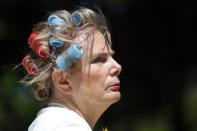 Carolyn Kirin wears curlers in her hair at a rally giving free haircuts at the State Capitol in Lansing, Mich., Wednesday, May 20, 2020. Barbers and hair stylists are protesting the state's stay-at-home orders, a defiant demonstration that reflects how salons have become a symbol for small businesses that are eager to reopen two months after the COVID-19 pandemic began. (AP Photo/Paul Sancya)
