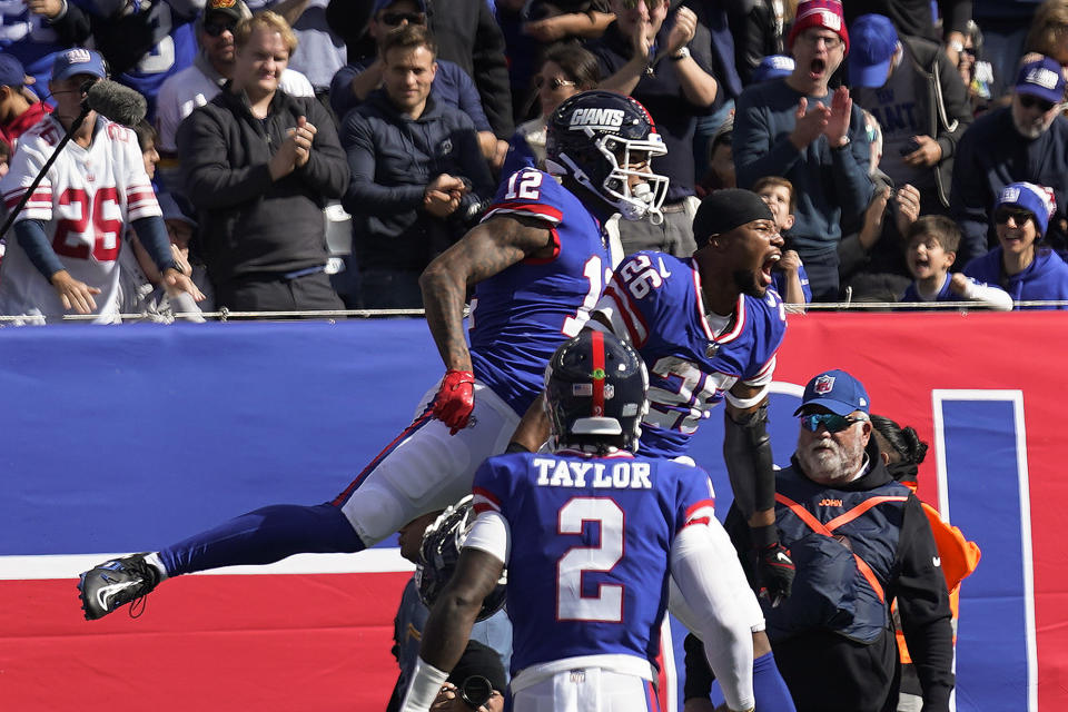 New York Giants tight end Darren Waller (12) celebrates with running back Saquon Barkley (26) after scoring a touchdown against the Washington Commanders during the second quarter of an NFL football game, Sunday, Oct. 22, 2023, in East Rutherford, N.J. (AP Photo/Seth Wenig)