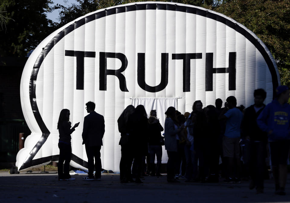 Students stand near a display on the campus of Hofstra University in Hempstead, N.Y., Tuesday, Oct. 6, 2012, site of the Presidential debate. President Barack Obama and Republican presidential candidate, former Massachusetts Gov. Mitt Romney will hold their second debate Tuesday. (AP Photo/Eric Gay)