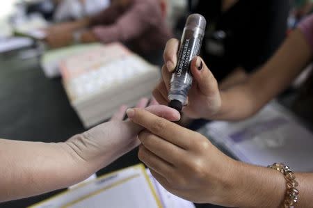 A woman gets her finger inked after casting her vote at a polling station during mid-term elections in the town of Santiago, state of Nuevo Leon, June 7, 2015. REUTERS/Daniel Becerril