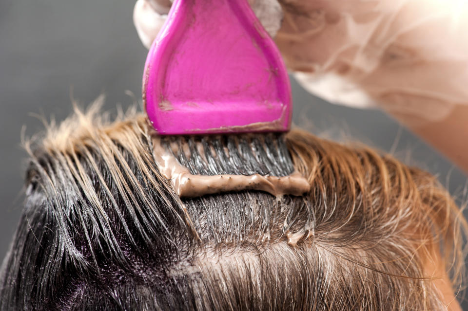 A radical change of hair color. Blonde woman master puts paint on her hair