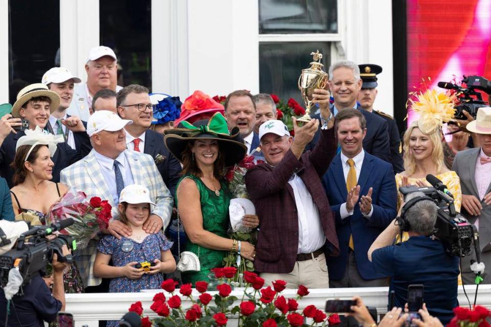 Lance Gasaway, one of Mystik Dan’s owners, hoists the trophy and celebrates with the Kentucky Derby winner’s connections.