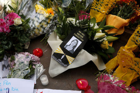 Candles and flowers are seen at an impromptu memorial during a protest by journalists following the assassination of investigative journalist Daphne Caruana Galizia in a car bomb attack three days ago, in Valletta, Malta, October 19, 2017. REUTERS/Darrin Zammit Lupi