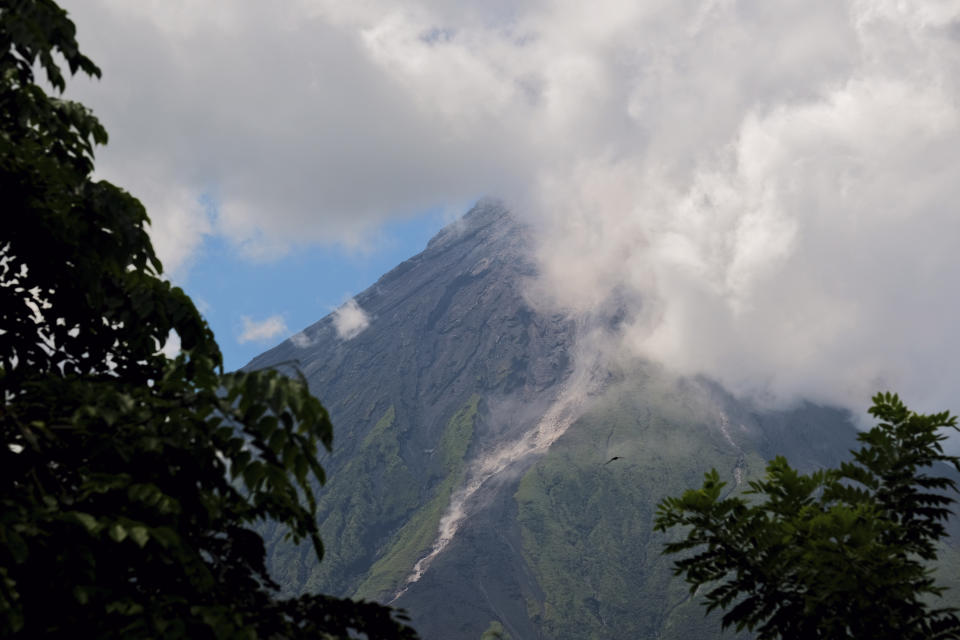 El volcán Mayon arroja humo blanco visto desde Daraga, en la provincia de Albay, en el centro de Filipinas, el 8 de junio de 2023. (AP Foto/John Michael Magdasoc)