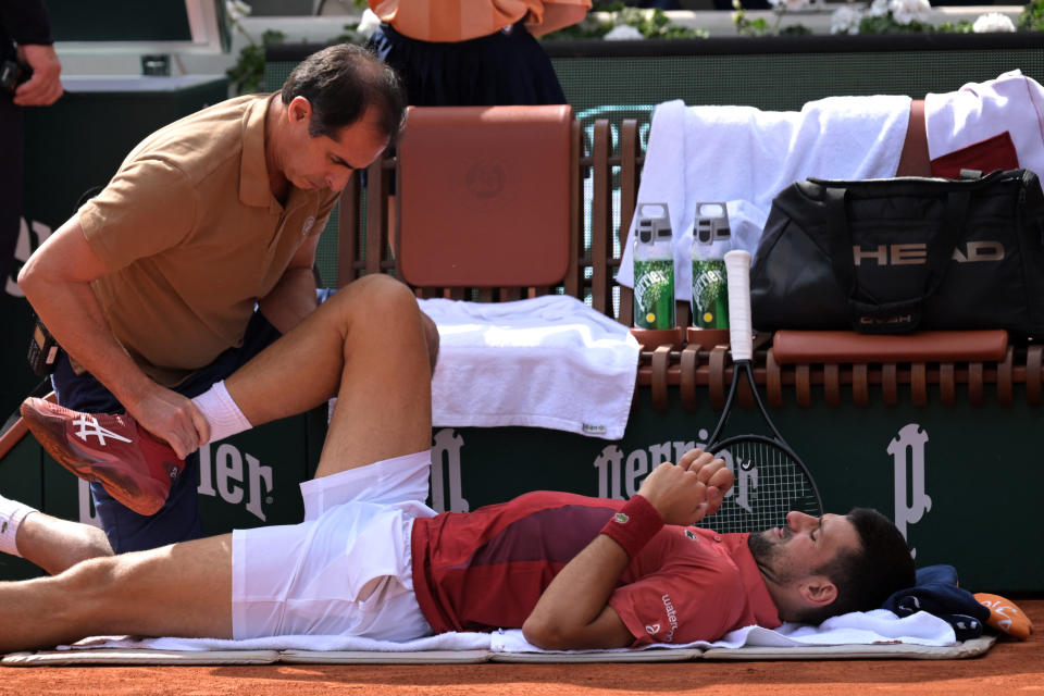 Serbia's Novak Djokovic receives medical treatment during his men's singles round of sixteen match against Argentina's Francisco Cerundolo on Court Philippe-Chatrier on day nine of the French Open tennis tournament at the Roland Garros Complex in Paris on June 3, 2024. (Photo by Bertrand GUAY / AFP) (Photo by BERTRAND GUAY/AFP via Getty Images)