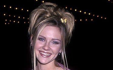 Kirsten Dunst with a messy up do hair style and butterfly clip in hair