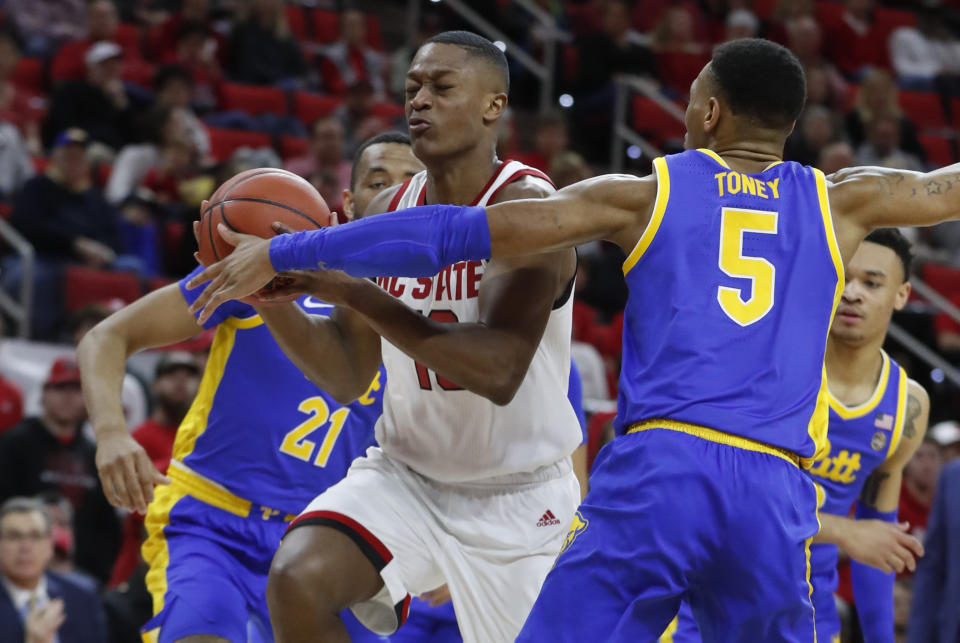 North Carolina State's C.J. Bryce (13) drives past Pittsburgh's Au'Diese Toney (5) during the first half of an NCAA college basketball game at PNC Arena in Raleigh, N.C., Saturday, Feb. 29, 2020. (Ethan Hyman/The News & Observer via AP)