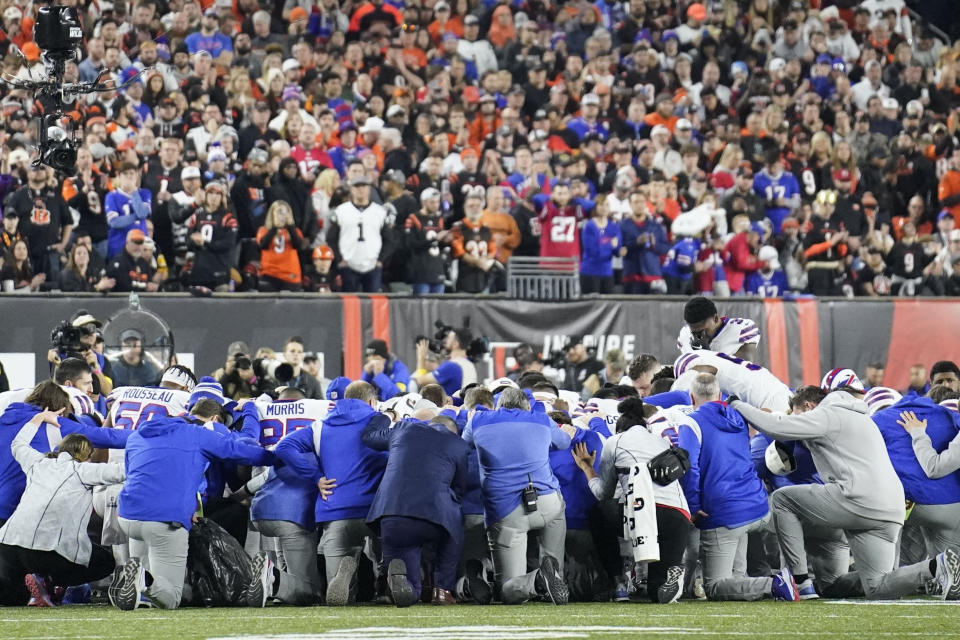 Buffalo Bills players and staff pray for Buffalo Bills' Damar Hamlin during the first half of an NFL football game against the Cincinnati Bengals, Monday, Jan. 2, 2023, in Cincinnati. The game has been postponed after Buffalo Bills' Damar Hamlin collapsed, NFL Commissioner Roger Goodell announced. (AP Photo/Joshua A. Bickel)