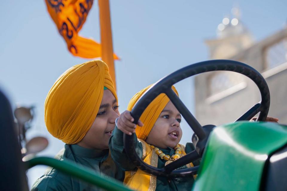 Agamjot Singh, 12, holds his brother Anandjot, 2, while he steers a tractor before the Sacramento Sikh Society’s first Nagar Kirtan parade on Sunday at the Sacramento Sikh Society Temple.